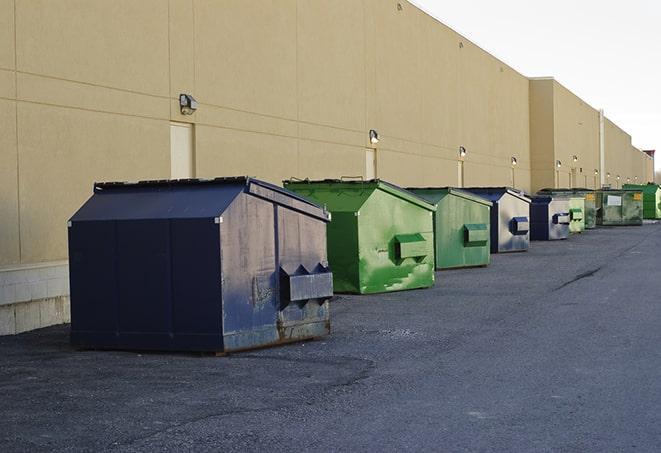 a pile of demolition waste sits beside a dumpster in a parking lot in Bingen